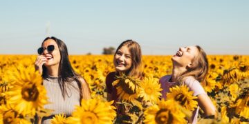 Chicas riendo entre girasoles