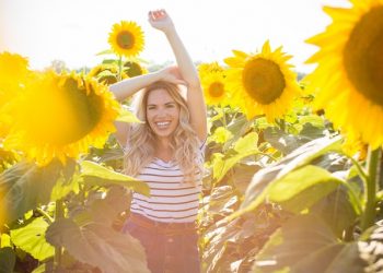 Chica sonriendo entre girasoles