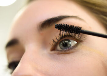 Mujer aplicándose una máscara de pestañas