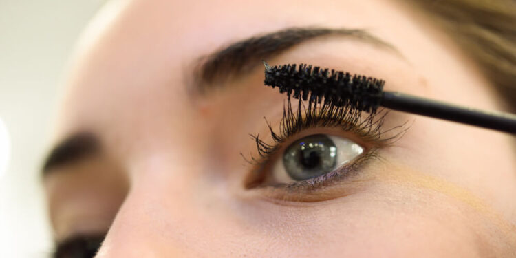 Mujer aplicándose una máscara de pestañas