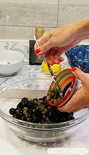 Añadiendo las alcaparras a las aceitunas negras