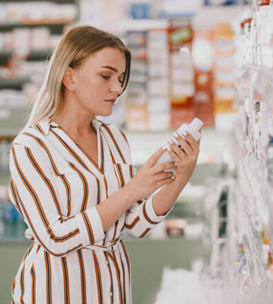 Mujer leyendo sellos ecológicos en cosmética
